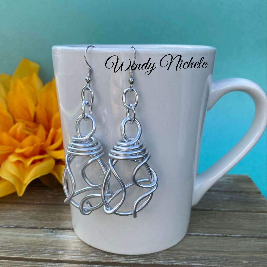 Knotted aluminum earrings on mug.webp